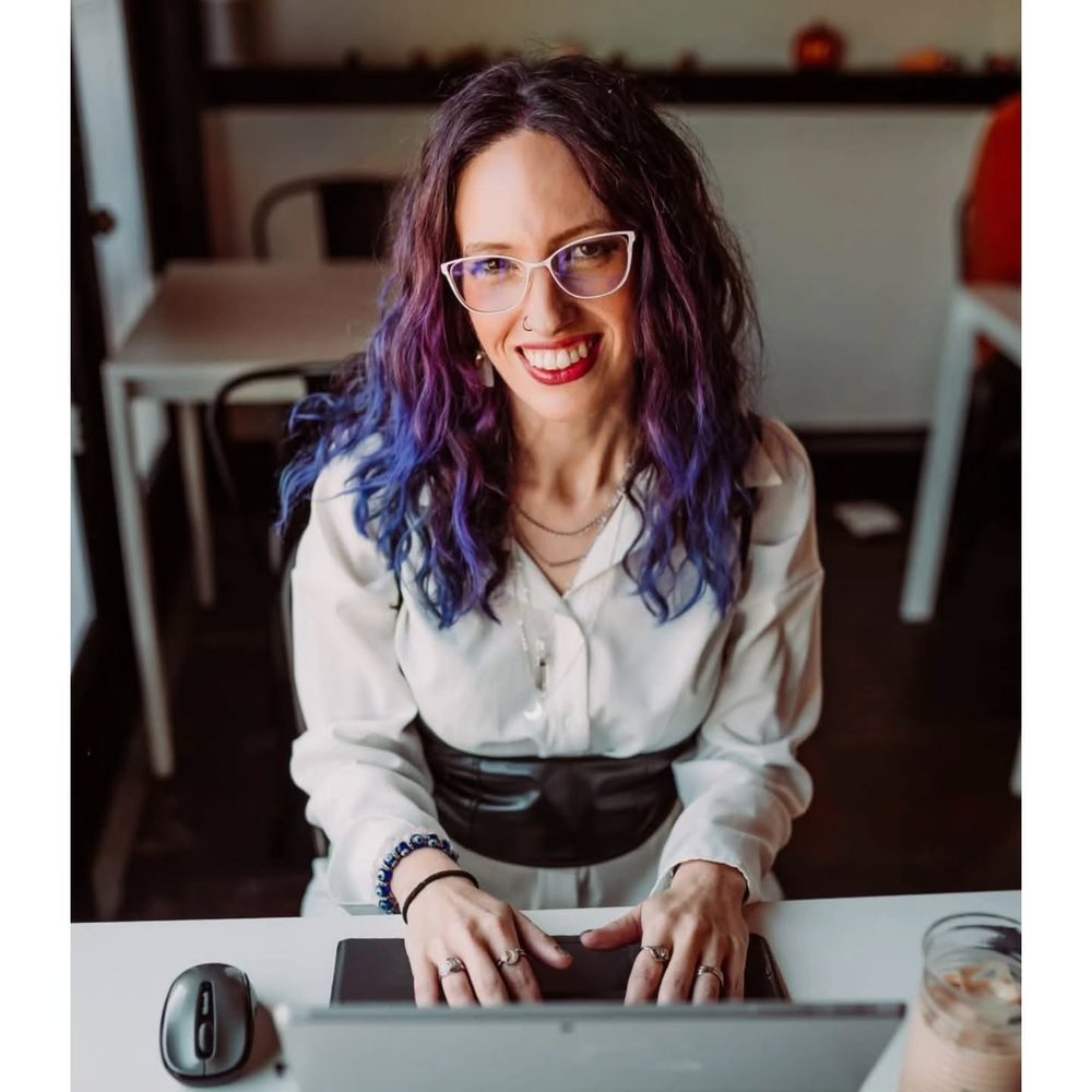 Angelita working at her laptop in a café